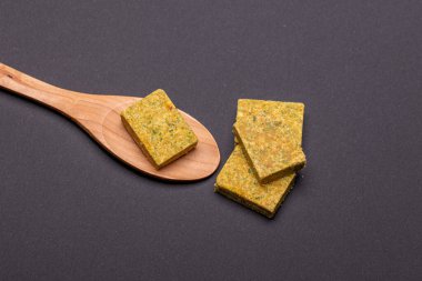 Vegetable bouillon stock or broth cube on wooden spoon