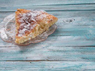 Traditional Bulgarian dish Banitsa with powder sugar on a wooden table