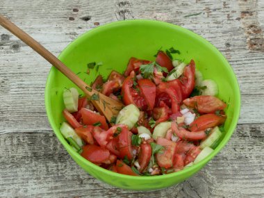 Ahşap rustik zemin üzerine taze sebze salatası. Domates, salatalık, soğan ve Avokado salatası