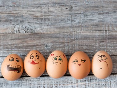 Eggs group in a  box with cheerful and mischievous faces having fun. Concept of joint recreation