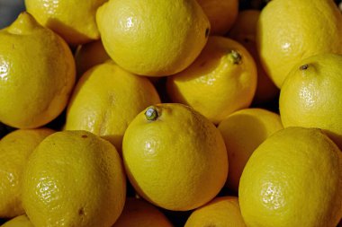 Colorful display of lemons In market. Macro photo of a ripe juicy lemon fruit.