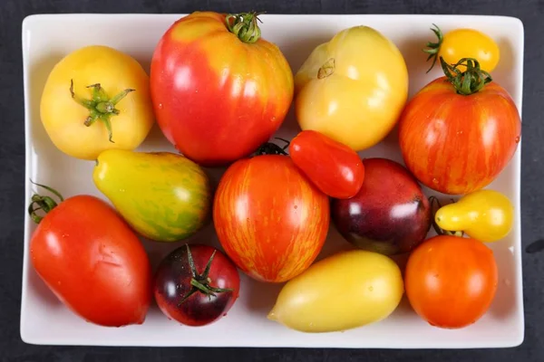 Tomates Coloridos Uma Chapa Fundo Preto — Fotografia de Stock