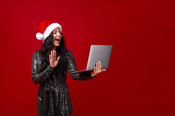 Een Vrouw Met Een Kerstmuts Houdt Een Laptop Vast Zwaait — Stockfoto