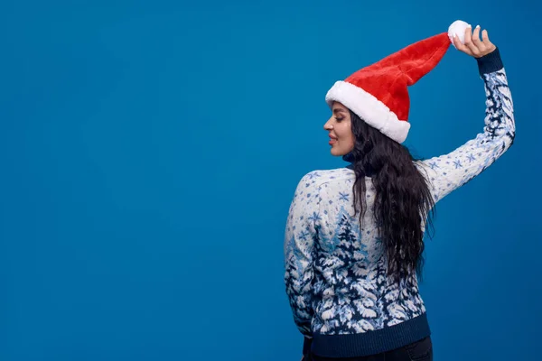 Een Vrouw Met Een Kerstmuts Staat Met Haar Rug Naar — Stockfoto