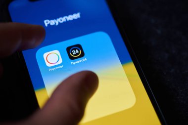 Ukraine, Kyiv, May 3, 2022 - Payoneer payment system. Payoneer and PrivatBank. Payoneer logo on the background of the flag of Ukraine