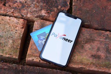 Ukrayna, Kyiv, 3 Mayıs 2022 - Akıllı telefon ekranındaki Payonez logosu tuğla bir arka plandaki bir banka kartında yatıyor