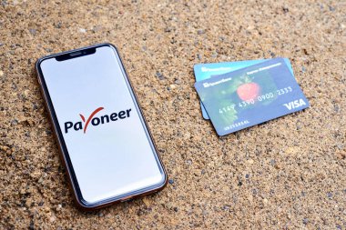 Ukrayna, Kyiv, 3 Mayıs 2022 - PrivatBank kartlarının yanındaki kumsalda herkesin logosu olan bir akıllı telefon bulunuyor