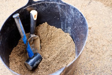 Döşeme kiremitleri büyük bir kum kovasının içinde. Ukrayna bayrağının renginde araçlar