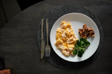 Siyah bir masada beyaz tabakta güzel bir kahvaltı.