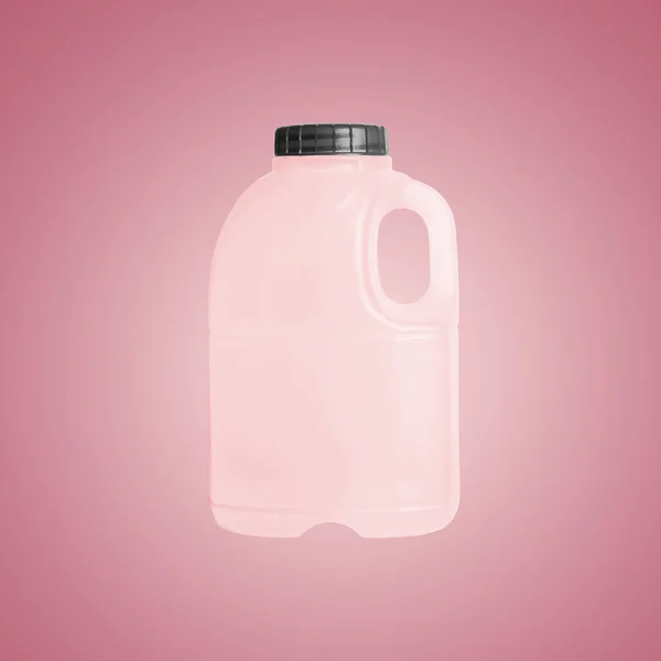 Delicate pink plastic bottle on a pink background. Pink canister with black cork — Stock fotografie