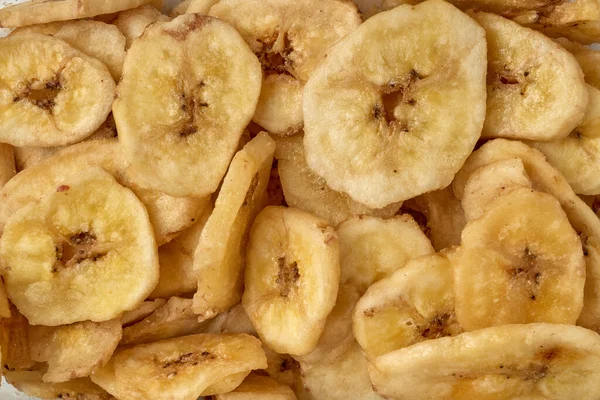 Banana chips background top view. Dried banana slices texture. Heap of dried bananas — Fotografia de Stock