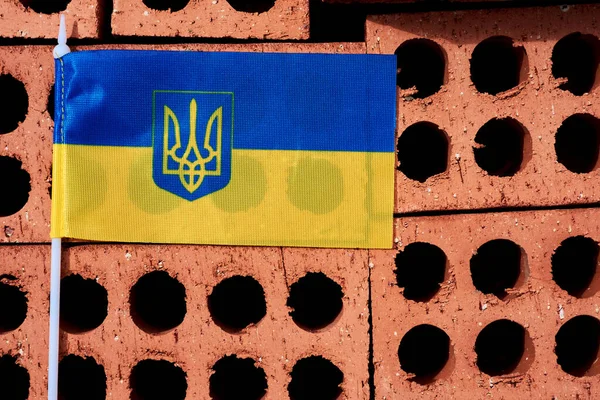 The Ukrainian flag lies on a stack of new bricks — Stok fotoğraf