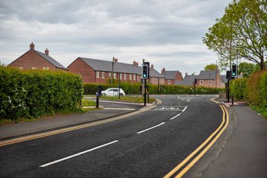Siyah asfaltı olan güzel bir Avrupa caddesi. Bir İngiliz köyündeki evler. Avrupa yolu