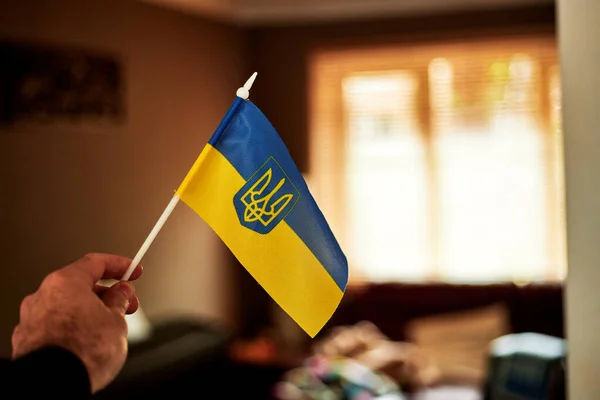 Un uomo tiene la bandiera dell'Ucraina davanti alla sua stanza. — Foto Stock