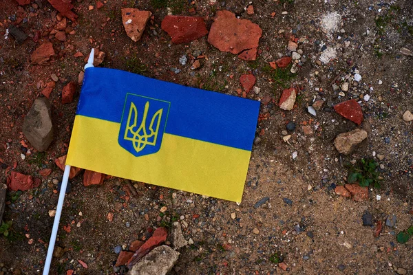 The flag of Ukraine lies on the ruins of a broken brick close-up —  Fotos de Stock