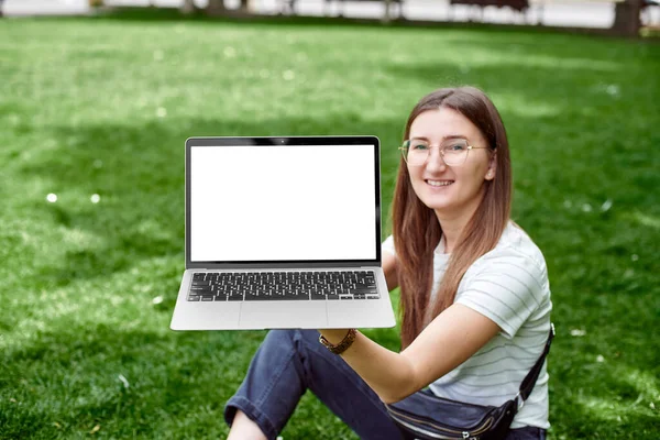 Девушка держит ноутбук на фоне своего лица — стоковое фото