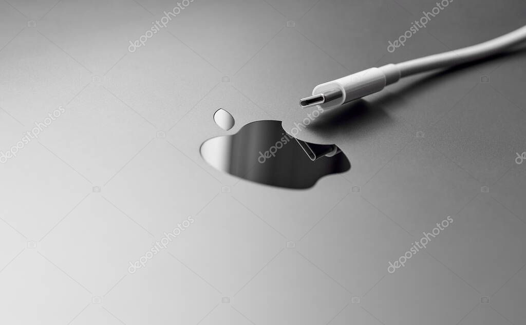 England, Newcastle, June 8, 2022: Type-C connector near the Apple logo. The EU has mandated that Apple use Type-C to charge its devices. Type-S for iPhone. Unified charging connector.