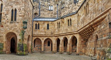 Alnwick Kalesi. Eski kalenin avlusunda kemerler var. İngiltere 'nin kuzeyinde eski bir sarı taş kale. Eski duvarların duvarlarında yosun var.. 