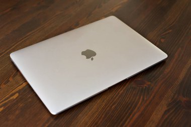 UK, Newcastle upon Tyne, 20 July 2022 - MacBook Air in gray lies closed on a wooden table. MacBook Air 2020-2022. New macBook Air with M1 processor. 