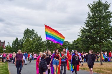Newcastle on Tyne, İngiltere, 23 Temmuz 2022 - Newcastle Pride. Genç insanların omuzlarında LGBTQ bayrakları var. Kız LGBTQ bayrağını taşıyor.