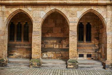 Alnwick Kalesi. Eski kalenin avlusunda kemerler var. İngiltere 'nin kuzeyinde eski bir sarı taş kale. Eski duvarların duvarlarında yosun var.. 