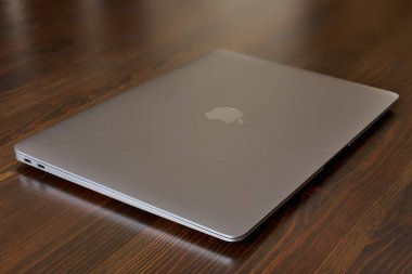 UK, Newcastle upon Tyne, 20 July 2022 - MacBook Air in gray lies closed on a wooden table. MacBook Air 2020-2022. New macBook Air with M1 processor. 