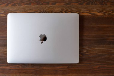 UK, Newcastle upon Tyne, 20 July 2022 - MacBook Air in gray lies closed on a wooden table. MacBook Air 2020-2022. New macBook Air with M1 processor. 