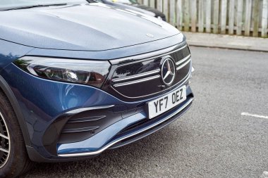 Tyne, İngiltere 'de Newcastle, 13 Temmuz 2022 - Kaldırımın kenarında yeni bir Mercedes EQA duruyor. Arabanın önü ve Mercedes logosu olan elektrikli arabanın ızgarası..