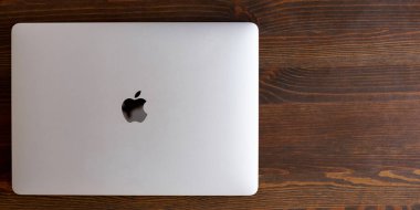 UK, Newcastle upon Tyne, 20 July 2022 - MacBook Air in gray lies closed on a wooden table. MacBook Air 2020-2022. New macBook Air with M1 processor. 