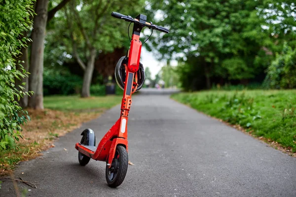 Orange Electric Scooter Stands Park Background Green Trees Imagen de stock