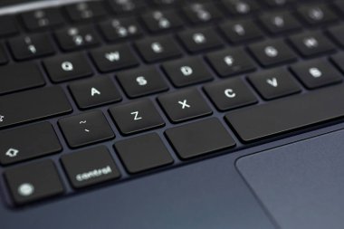 Modern, slim, backlit laptop membrane keyboard. Black keyboard large board. Selective focus. close-up of laptop keys.