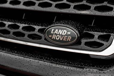 UK, Newcastle, 27 August 2022: Range Rover Evoque. The Land Rover logo is close-up on the black grille in the droplets. Drops on the Renge Rover logo.