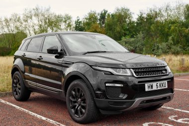UK, Newcastle, 27 August 2022: Range Rover Evoque 2015 in black colour. Completely black car with carbon lettering on the hood.