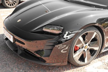 UK, Newcastle, 27 August 2022: The 2021 Porsche Taycan in black is parked in the parking lot. Sports electric car.