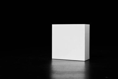 White square box insulated on a black background. Small paper box