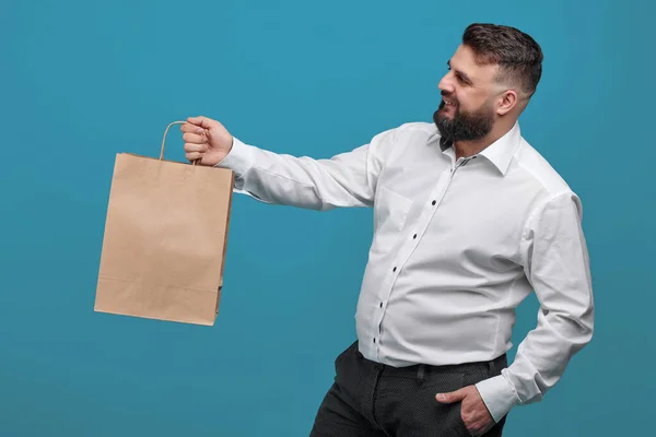 Ein Bärtiger Mann Hält Eine Kleine Braune Papiertüte Die Höhe — Stockfoto