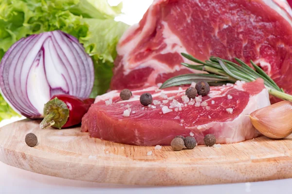 Raw meat, vegetables and spices on wooden board Stock Picture