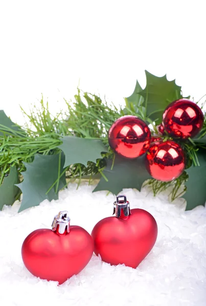 Christmas background with red balls, hearts, holly leaves and berries — Stock Photo, Image