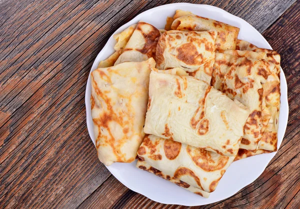 Pancakes with meat on a plate on wooden background — Stock Photo, Image