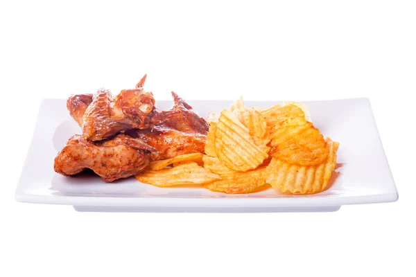 Жареные куриные крылышки с картофельными чипсами на белом фоне — стоковое фото