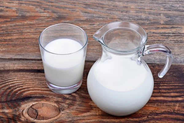 Jarra de vidrio y vaso con leche —  Fotos de Stock