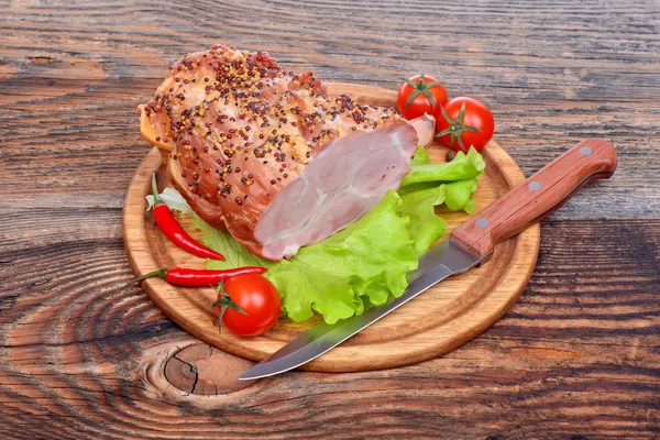 Cuello de cerdo al horno, tomates, pimientos, ajo y cuchillo —  Fotos de Stock