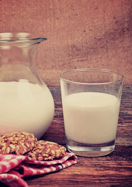 Glaskanne und Glas mit Milch und Keksen — Stockfoto
