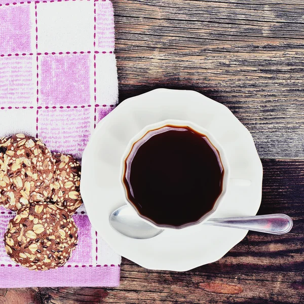 Biscoitos de cereal orgânicos em uma chapa e chá em fundo de madeira — Fotografia de Stock