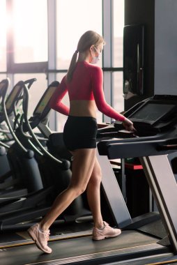 Genç kaslı kadın spor salonunda spor paspası üzerinde vücut egzersizi yapıyor, sağlık kulübünde şınav çekiyor..