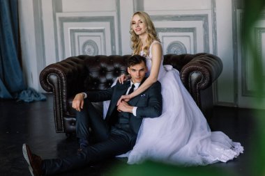 Klasik bir stüdyonun içinde şirin bir düğün çifti. Öpüşüyorlar ve sarılıyorlar..