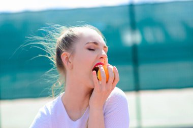 Beyaz elbiseli ve elinde tenis raketi olan kadın oyuncu. Genç kadın tenis oynuyor.