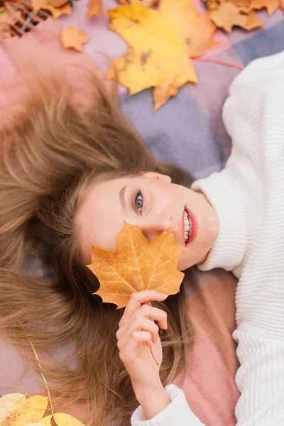 季節と人々のコンセプト 秋のカエデの葉を持つ美しい若い女性が地面に横たわっている — ストック写真