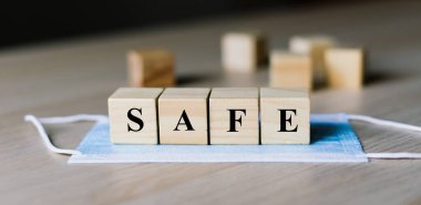 Mavi cerrahi yüz maskesi ve tahta bloklama kelimesi güvenli. Coronavirus. Sağlık ve Tıp Konsepti.