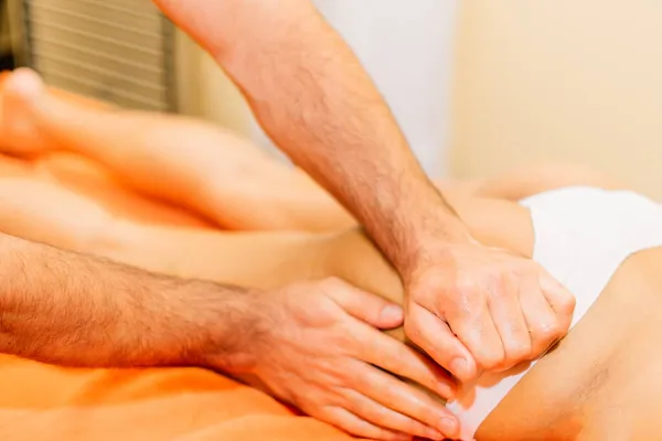 An attractive latin american woman lying down on a massage bed at a spa — Stock Photo, Image